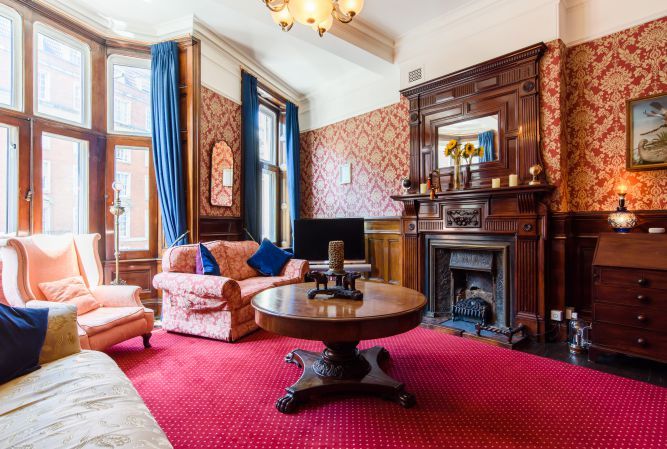 The mahogany-panelled sitting room with its carved fireplace